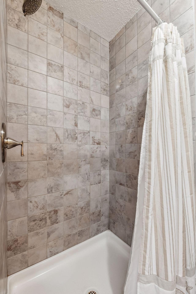 bathroom featuring a textured ceiling and a shower with shower curtain