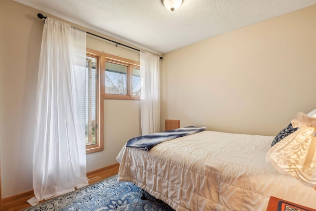 bedroom featuring a textured ceiling and hardwood / wood-style flooring