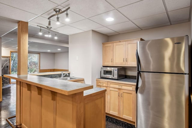 kitchen featuring light brown cabinetry, a center island, stainless steel appliances, and sink