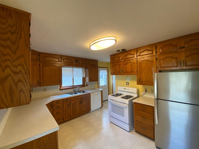 kitchen with sink, backsplash, and white appliances