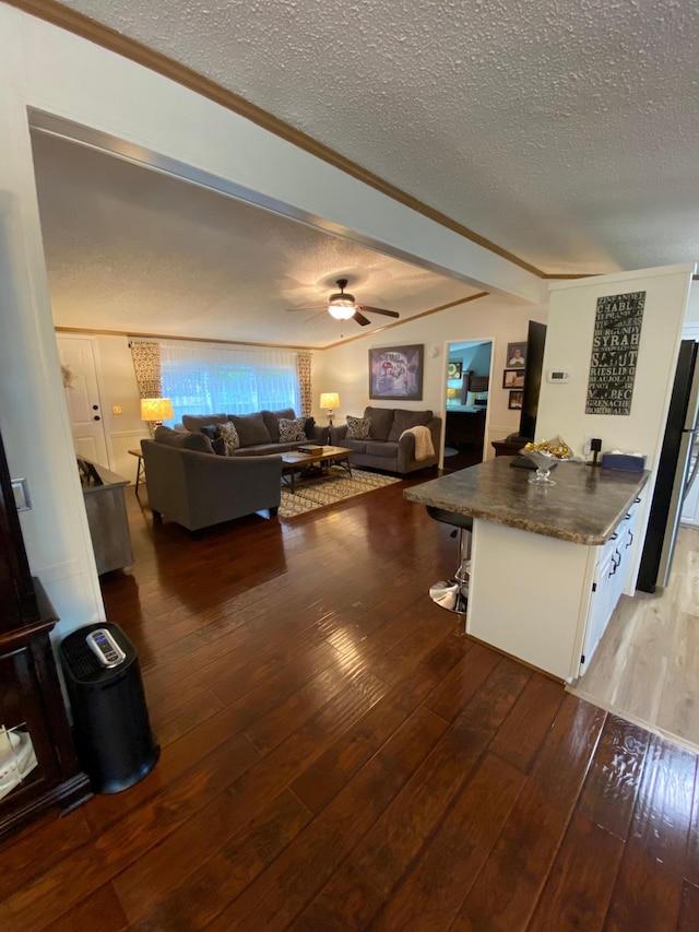 kitchen featuring wood-type flooring, stainless steel fridge, white cabinetry, a textured ceiling, and ceiling fan