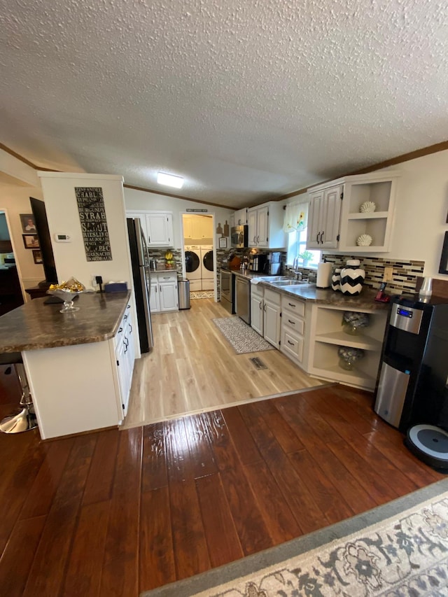 kitchen with washer and clothes dryer, a textured ceiling, light wood-type flooring, and white cabinets