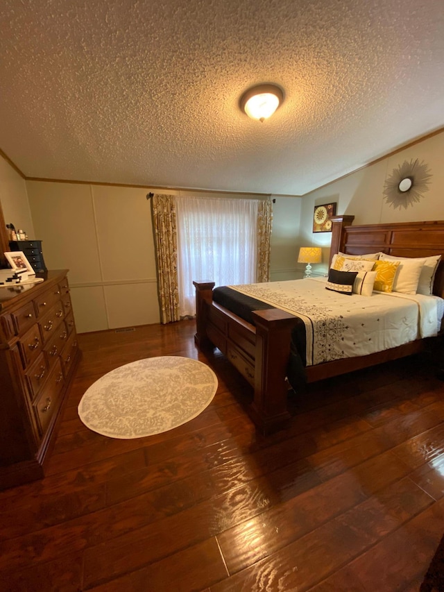 bedroom featuring a textured ceiling and dark hardwood / wood-style floors