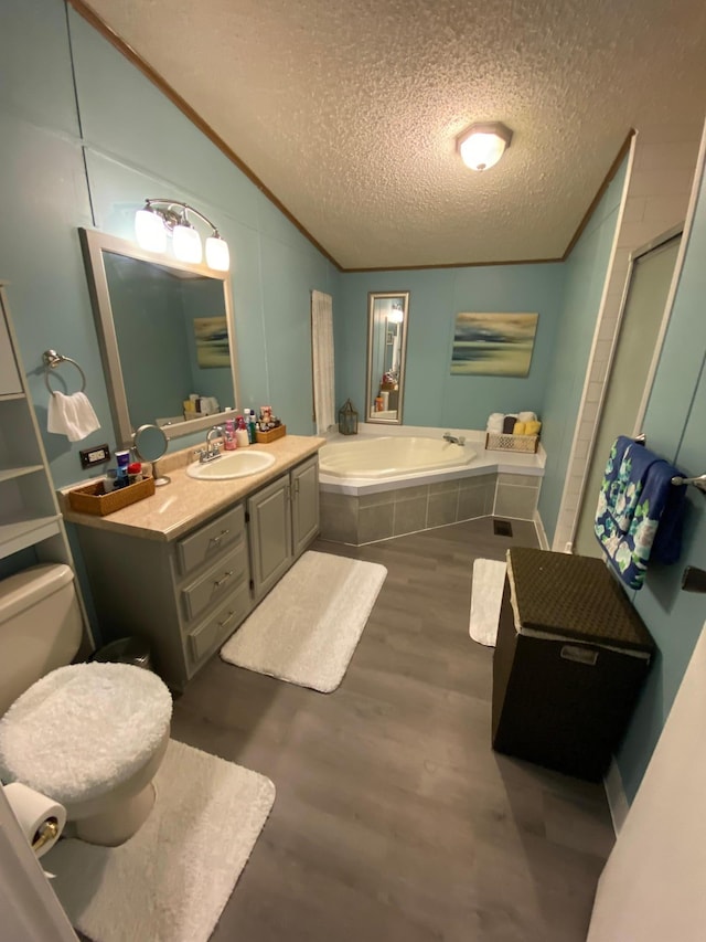 full bathroom featuring lofted ceiling, a textured ceiling, hardwood / wood-style flooring, toilet, and vanity