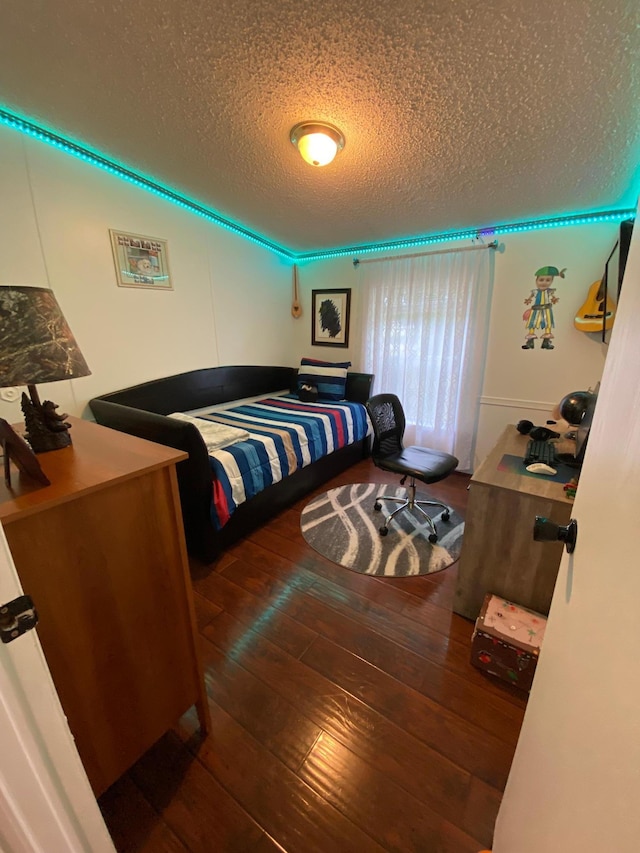 bedroom with a textured ceiling and dark hardwood / wood-style floors