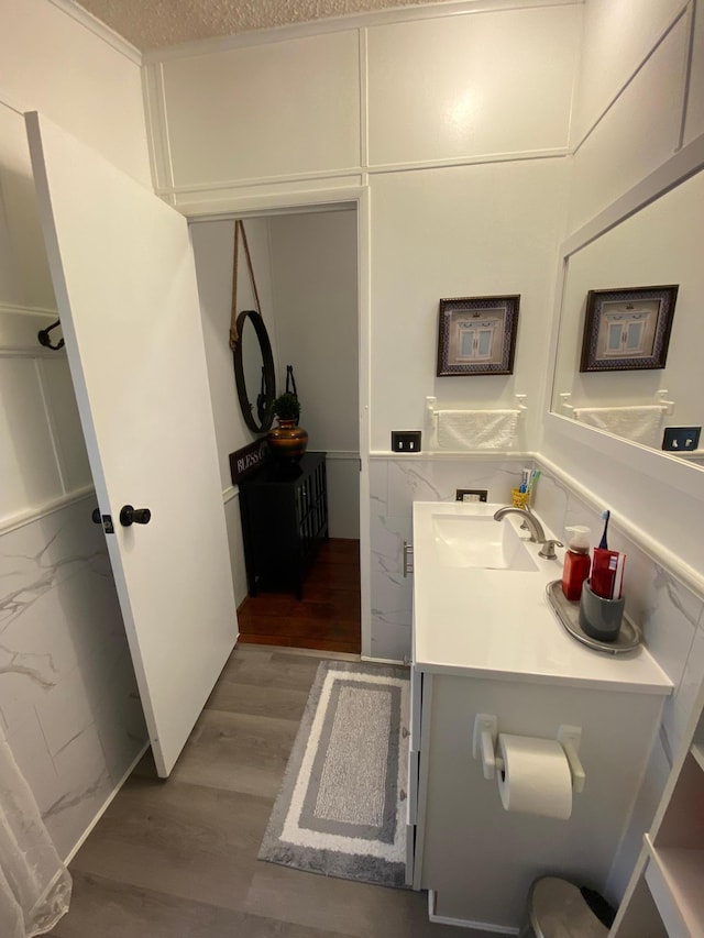 bathroom featuring vanity, a textured ceiling, and wood-type flooring