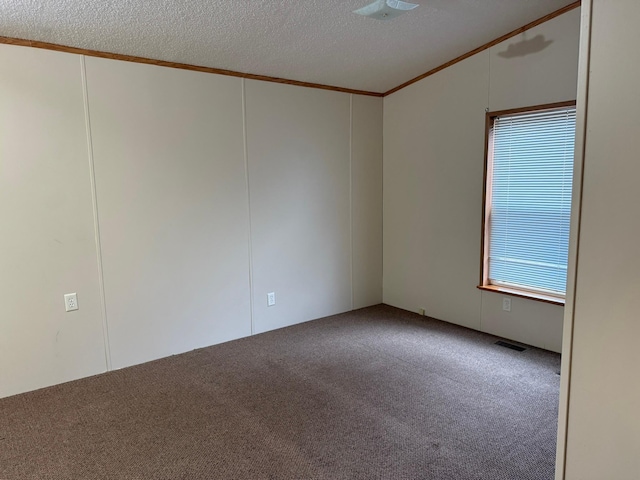 empty room with carpet, ornamental molding, and a textured ceiling