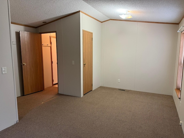 unfurnished bedroom with a textured ceiling, carpet floors, vaulted ceiling, and a closet