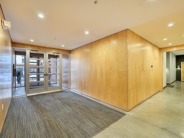 spare room featuring concrete floors and wooden walls