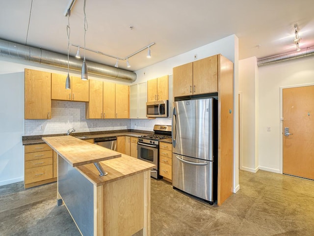 kitchen with tasteful backsplash, appliances with stainless steel finishes, light brown cabinetry, butcher block counters, and a center island