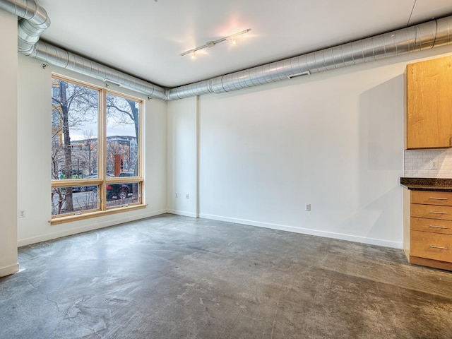 unfurnished room with concrete flooring and rail lighting