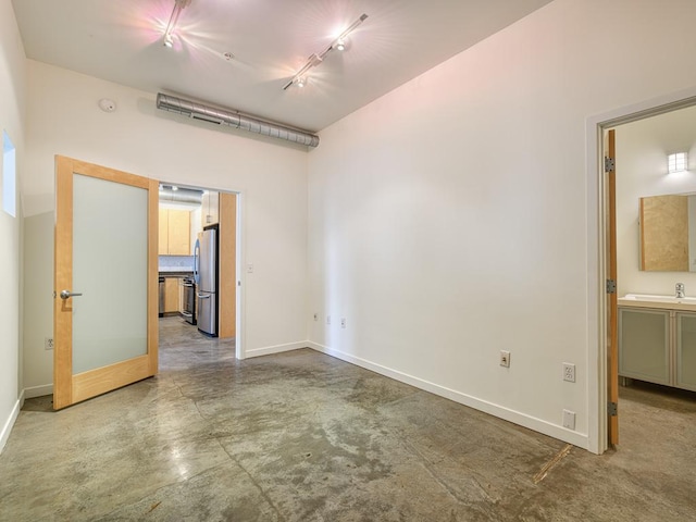 empty room featuring concrete flooring and rail lighting