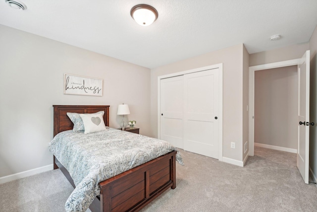 bedroom featuring light colored carpet and a closet