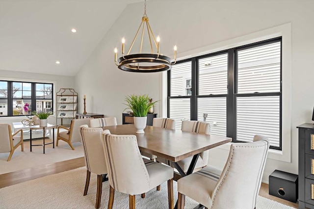 dining room featuring light hardwood / wood-style flooring, high vaulted ceiling, and an inviting chandelier