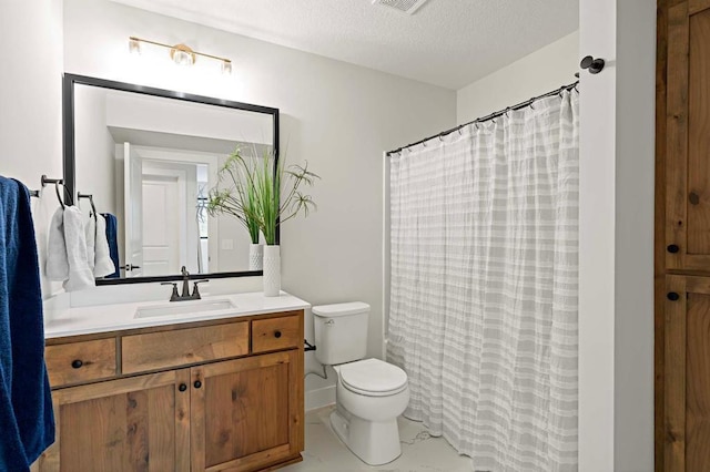 bathroom featuring a textured ceiling, vanity, and toilet