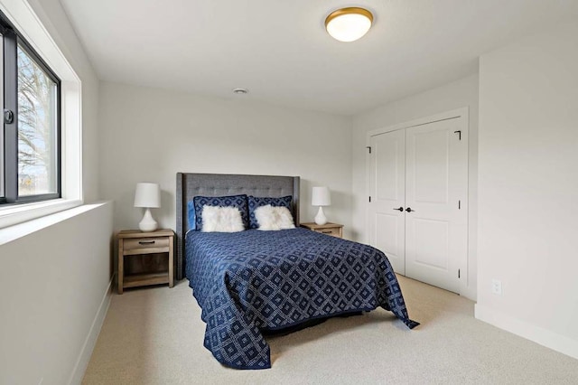 bedroom with light colored carpet and a closet