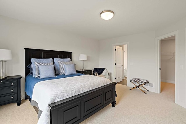 carpeted bedroom featuring a spacious closet and a closet