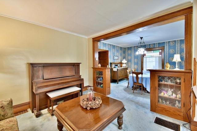 sitting room with visible vents, baseboards, ornamental molding, carpet, and wallpapered walls