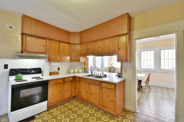 kitchen with light floors, light countertops, electric range oven, under cabinet range hood, and a sink