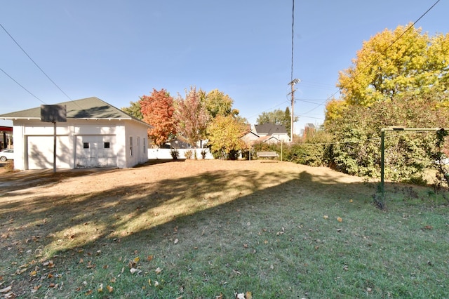 view of yard featuring an outdoor structure, a fenced backyard, and a detached garage