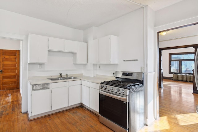 kitchen featuring white cabinetry, light hardwood / wood-style floors, and stainless steel gas range