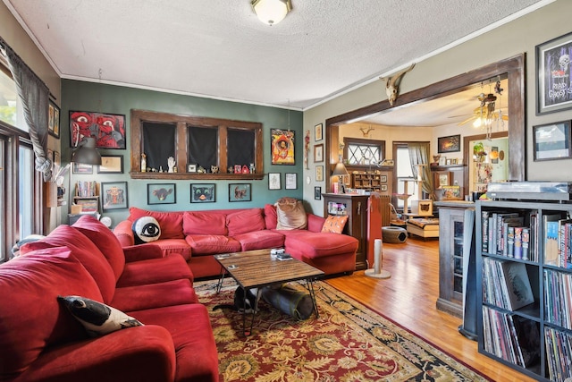 living room featuring a wealth of natural light, hardwood / wood-style floors, a textured ceiling, and ornamental molding