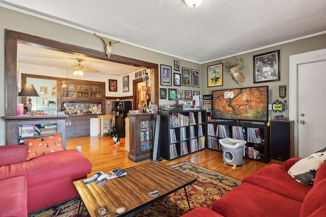 living room with a textured ceiling, hardwood / wood-style flooring, and crown molding