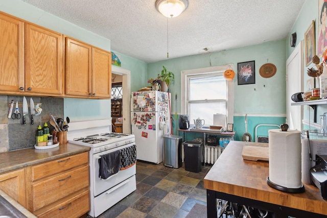 kitchen with backsplash, white appliances, and a textured ceiling