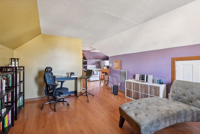 office with a textured ceiling, light hardwood / wood-style flooring, and lofted ceiling