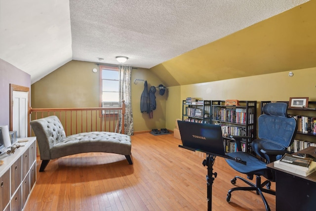 office area featuring wood-type flooring, a textured ceiling, and lofted ceiling