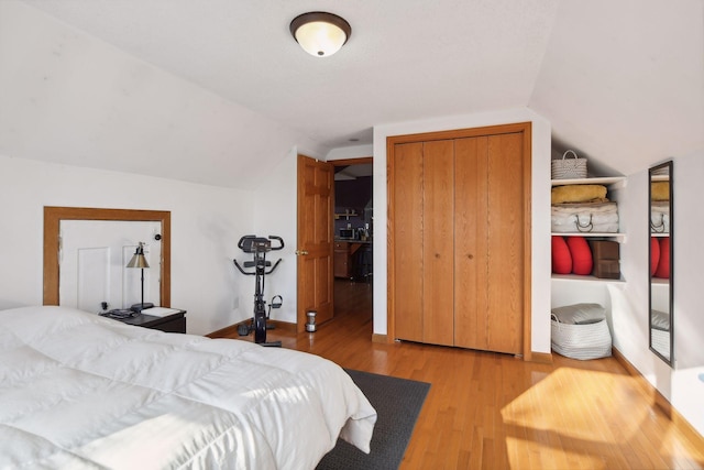 bedroom featuring a closet, hardwood / wood-style floors, and lofted ceiling