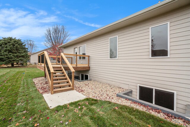 view of side of property with a yard and a deck