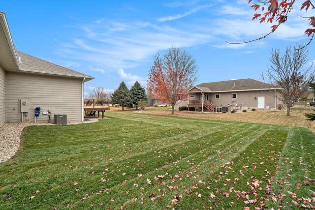 view of yard with central air condition unit and a deck