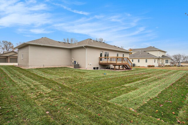 rear view of house featuring a deck, central AC unit, and a lawn