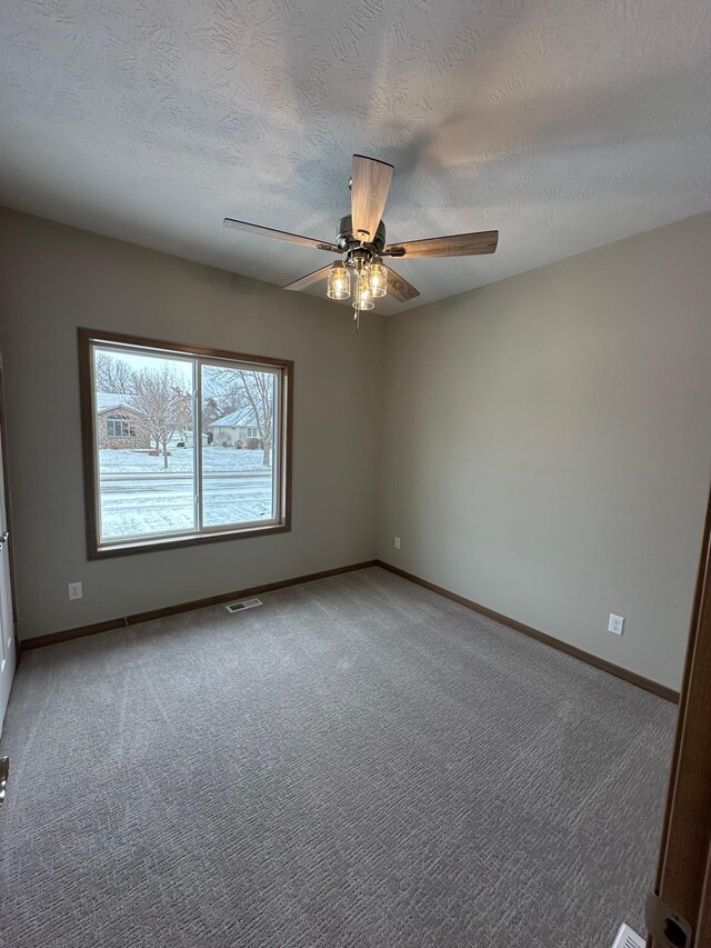 spare room featuring ceiling fan, carpet, and a textured ceiling