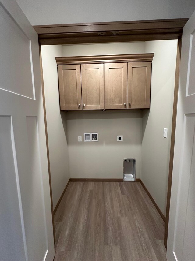 clothes washing area featuring cabinets, washer hookup, hardwood / wood-style flooring, and electric dryer hookup