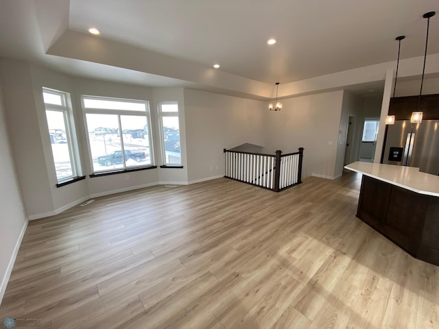 1312 Southview Dr SW, Glyndon, MN 56547 - unfurnished living room with light wood-type flooring, baseboards, recessed lighting, a chandelier, and a raised ceiling