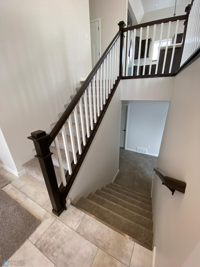 1312 Southview Dr SW, Glyndon, MN 56547 - staircase with tile patterned floors, a high ceiling, and baseboards