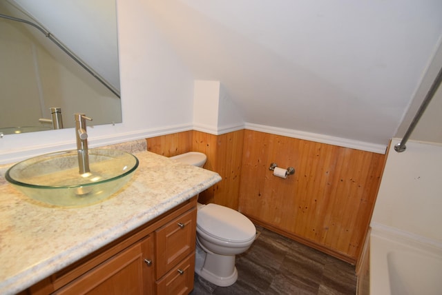 bathroom featuring wood walls, vanity, toilet, and wood-type flooring