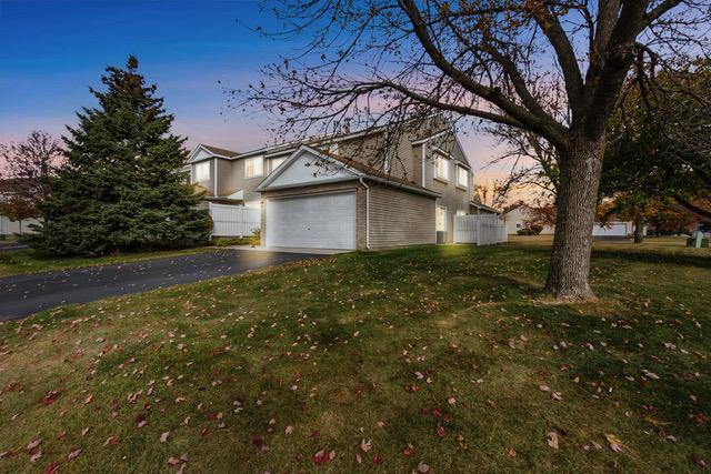 property exterior at dusk with a yard and a garage