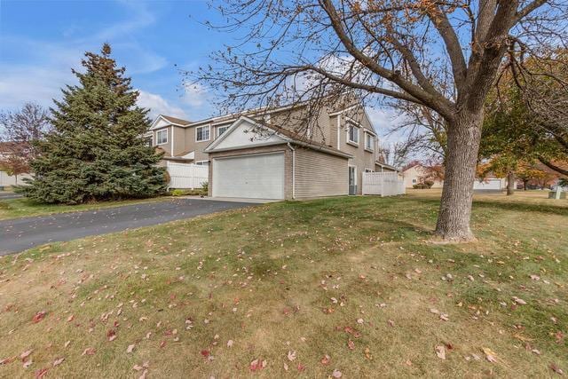 view of home's exterior with a garage and a lawn