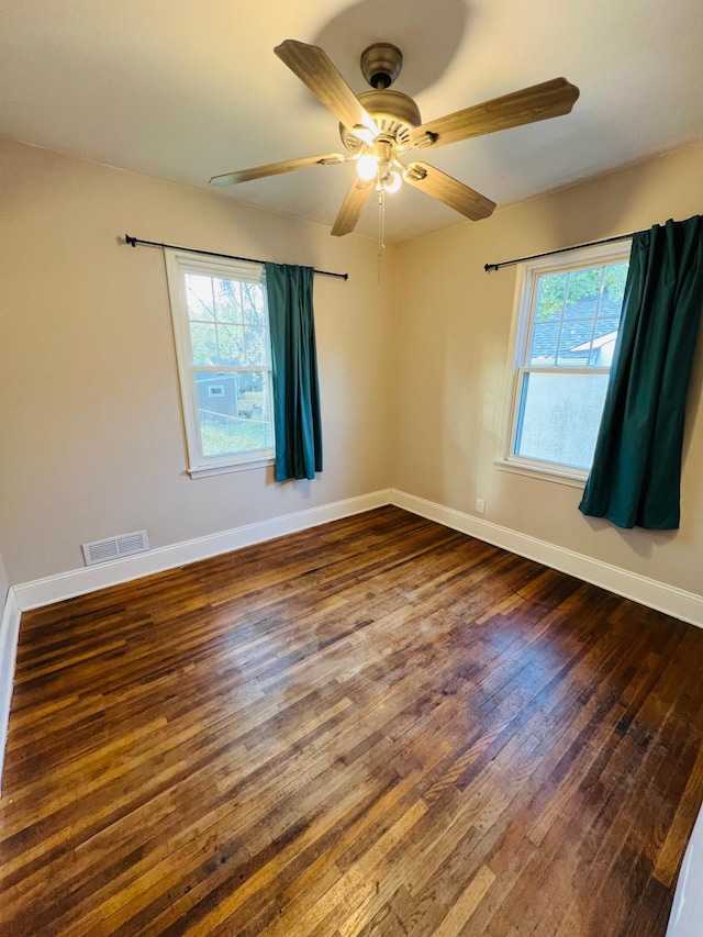 unfurnished room with hardwood / wood-style floors, a healthy amount of sunlight, and ceiling fan