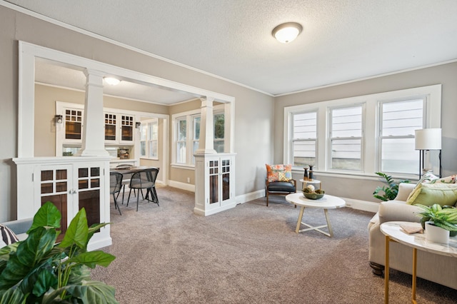 living room with carpet, a textured ceiling, decorative columns, and ornamental molding