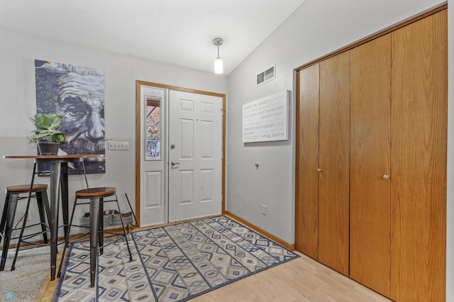 entryway featuring light hardwood / wood-style floors and lofted ceiling