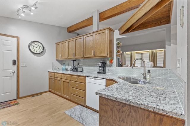 kitchen featuring sink, white dishwasher, light stone countertops, light hardwood / wood-style flooring, and decorative backsplash