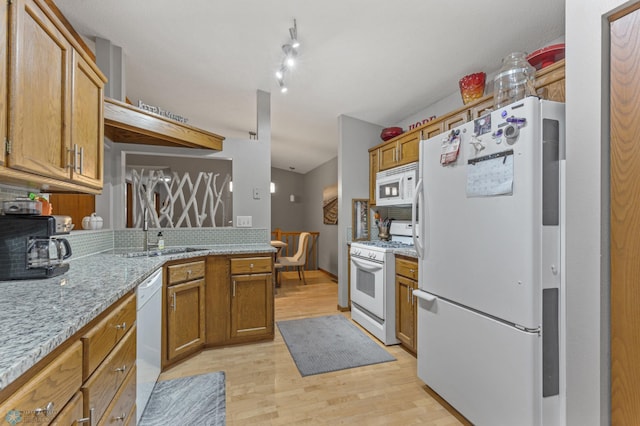 kitchen featuring white appliances, light stone countertops, and light wood-type flooring