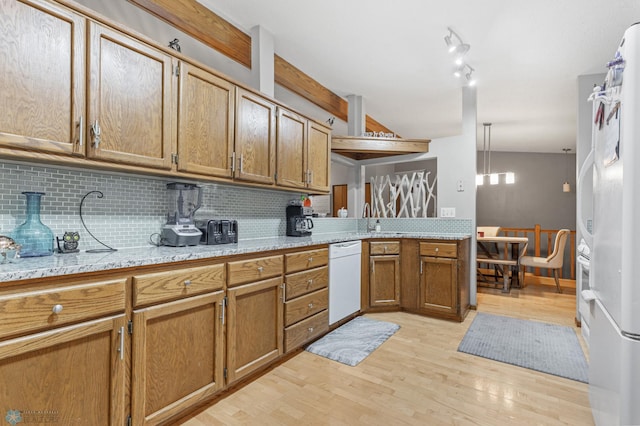 kitchen with backsplash, white appliances, light hardwood / wood-style flooring, and kitchen peninsula