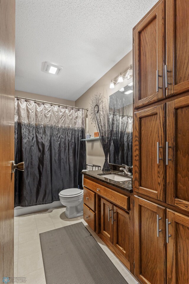 bathroom with vanity, walk in shower, a textured ceiling, and toilet