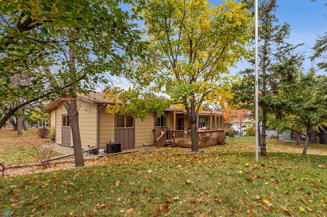 back of house featuring a lawn, a wooden deck, and cooling unit