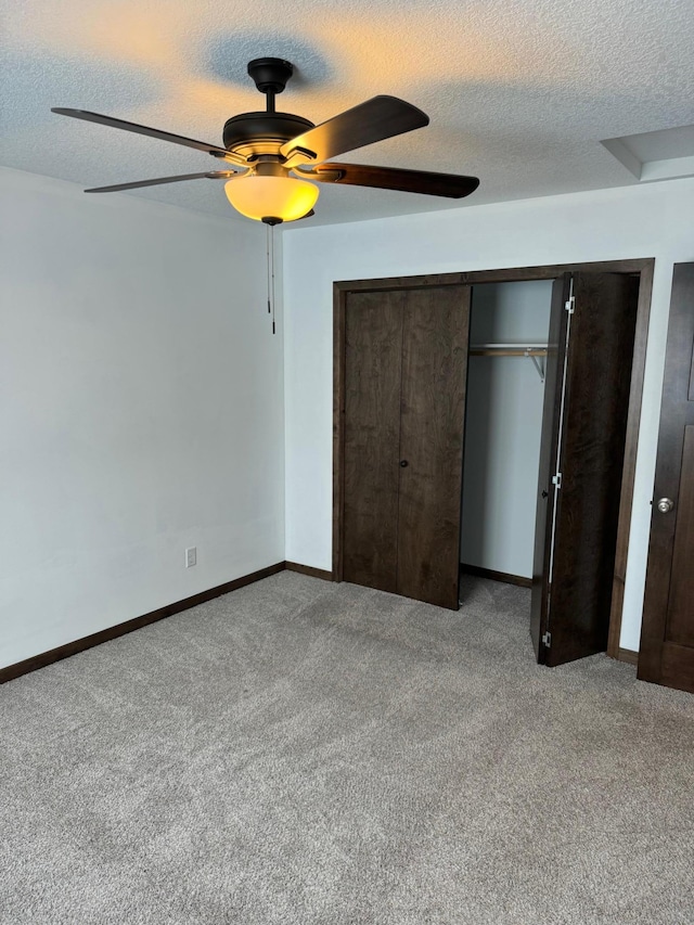 unfurnished bedroom with a textured ceiling, light colored carpet, and ceiling fan